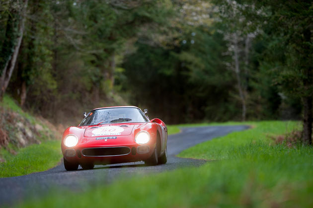 Ferrari 250 racing down a road in the country side