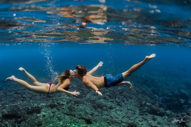 Underwater couple kisses in ocean