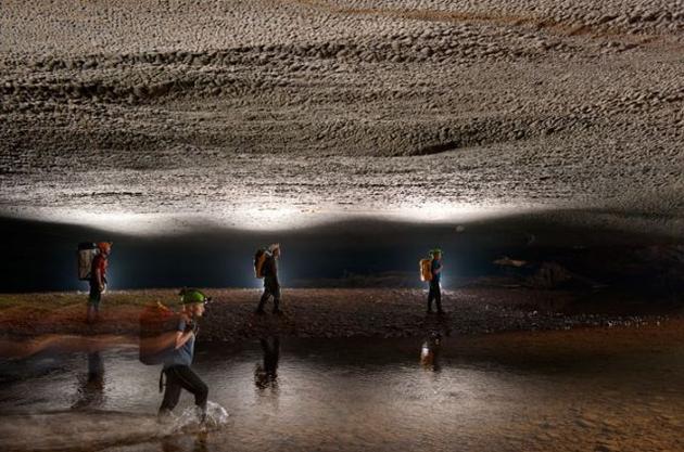 Scientists venturing under the low ceiling of the cave